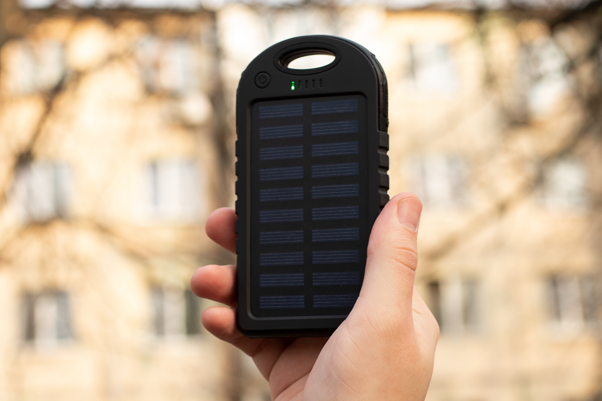 Man holding in hand charger with solar battery.